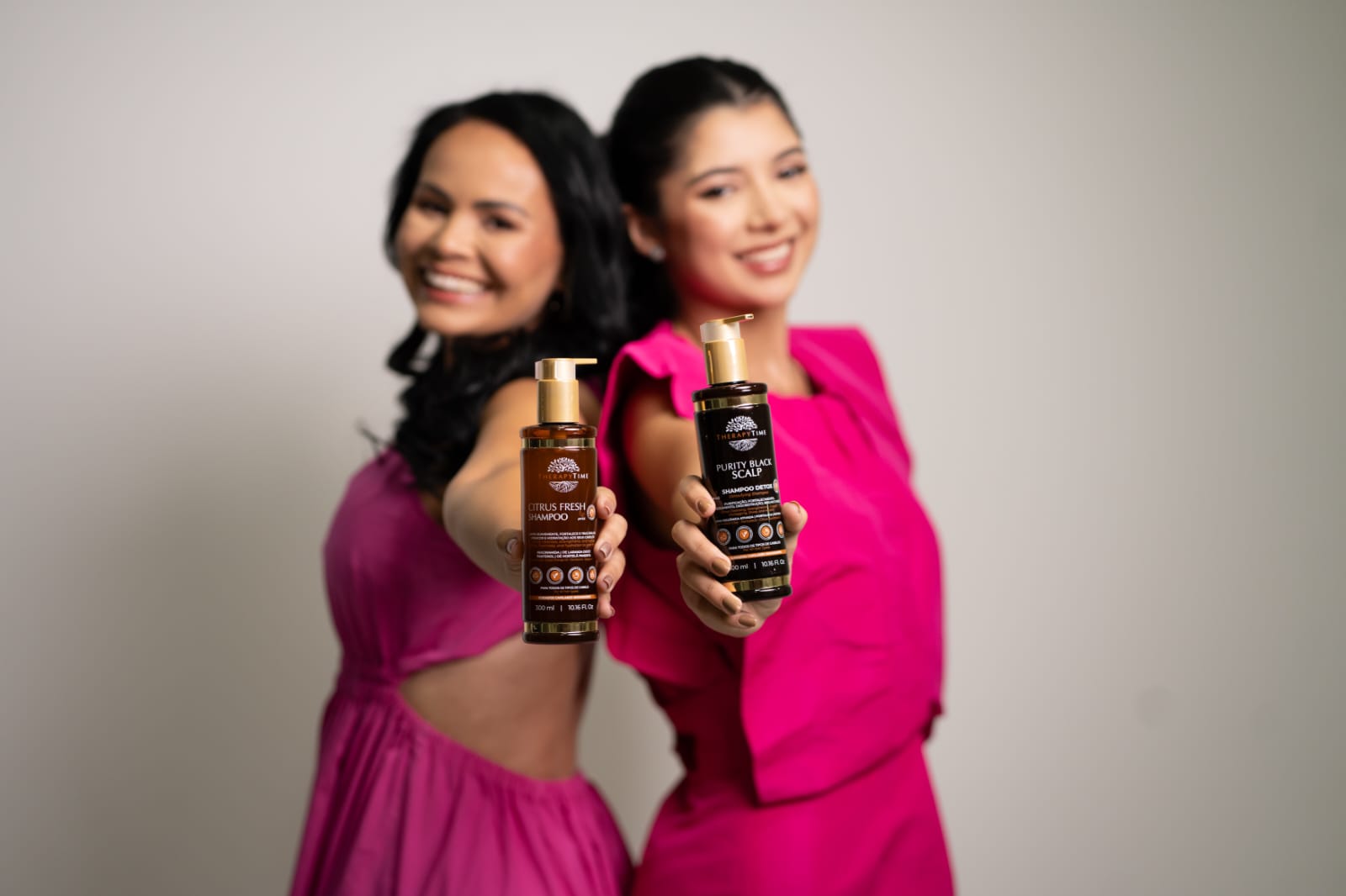 Duas mulheres da Therapy Time vestidas de rosa, sorrindo no ensaio institucional